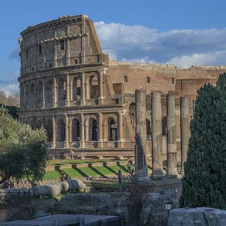 The Colosseum rising behind the columns and ruins of the Roman Forum