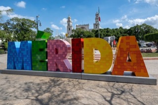 The Plaza Grande in Mérida, with the cathedral towers behind the city sign
